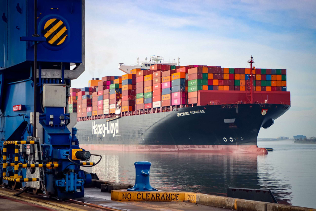 Hapag-Lloyd container ship docked at South Carolina port, fully loaded with multicolored cargo containers, highlighting maritime trade logistics.